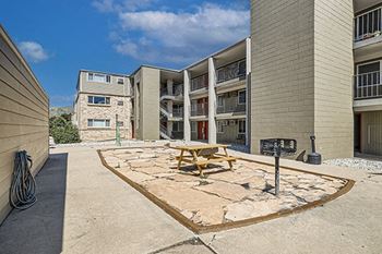 a picnic table sits in a courtyard in front of an apartment building